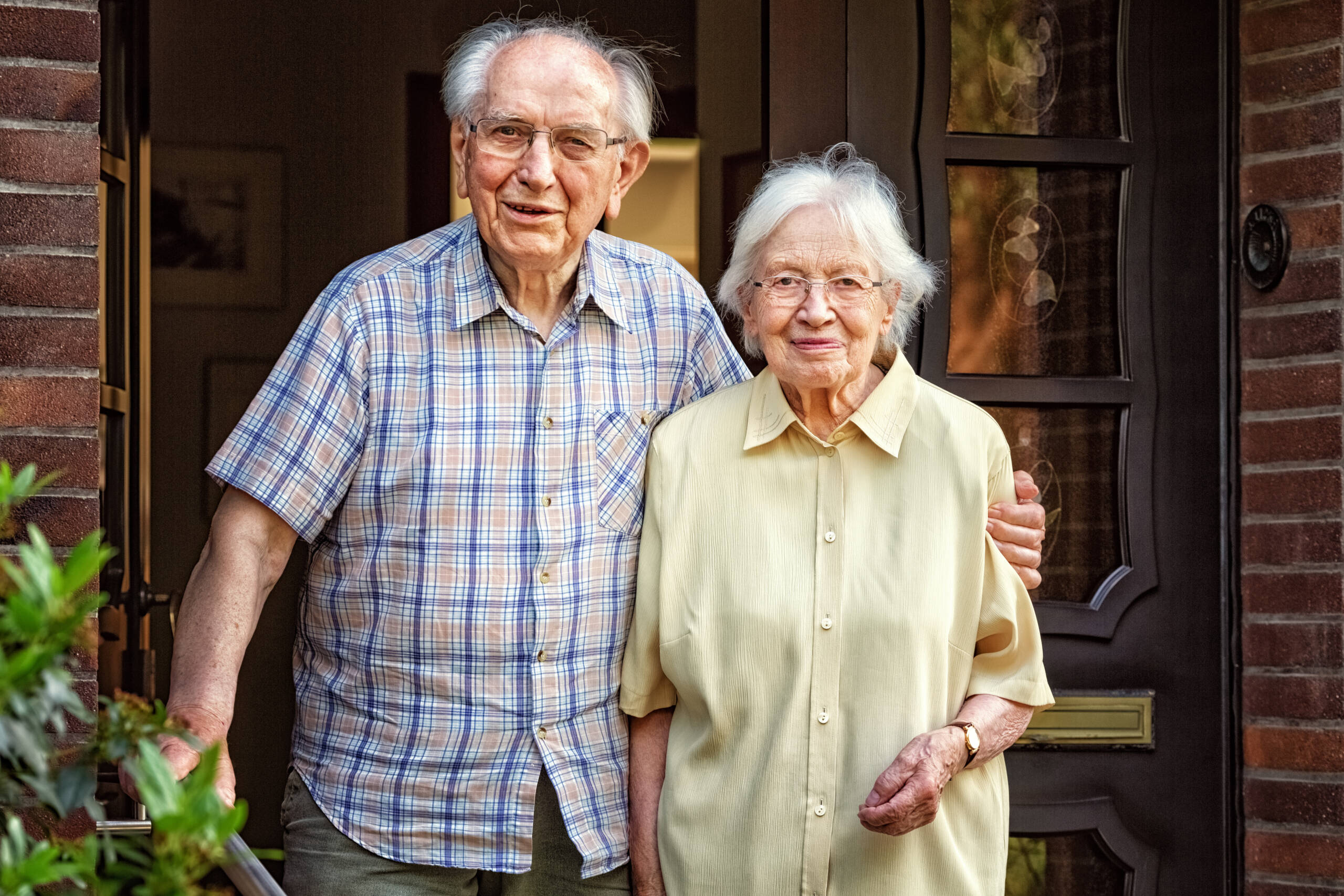 happy elderly couple at front door